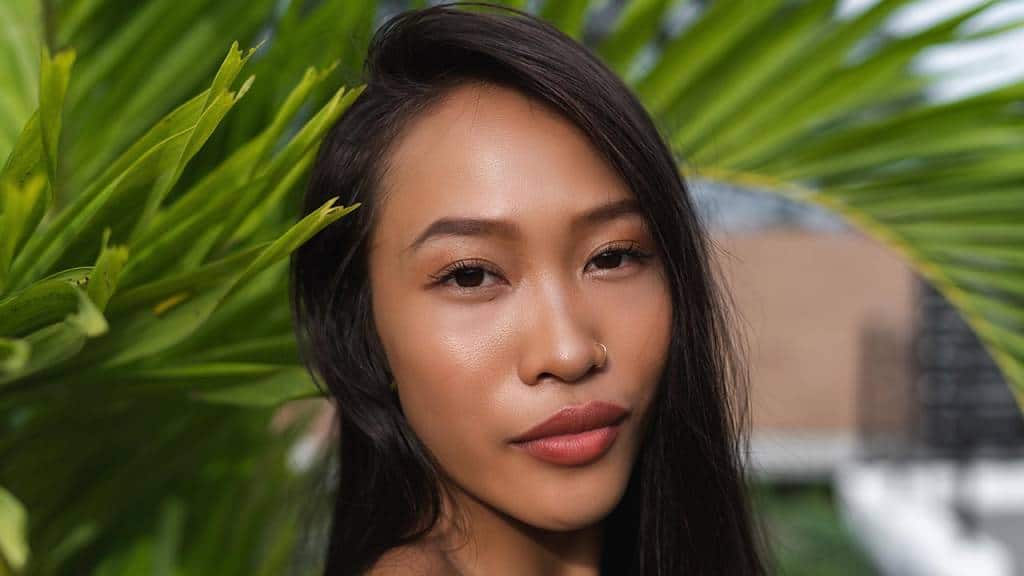 asian woman with eyelash extensions in nature